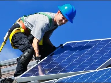 Worker installing solar panel